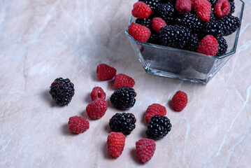 Blackberry and raspberry in a transparent bowl close-up