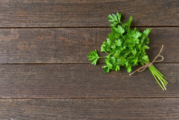 bunch of fresh parsley on wooden table, top view. Copy space for text.