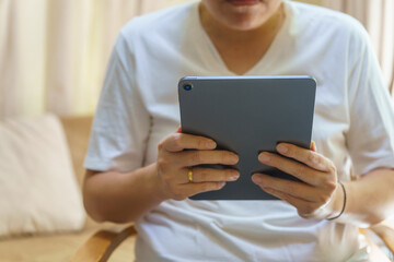 Technology Concept. Closeup of computer tablet in Asian man hand in living room