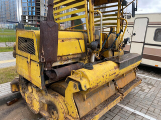 Yellow powerful old road small roller for asphalt paving and road repair at a construction site....