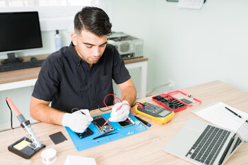 Young man measuring the voltage of a smartphone
