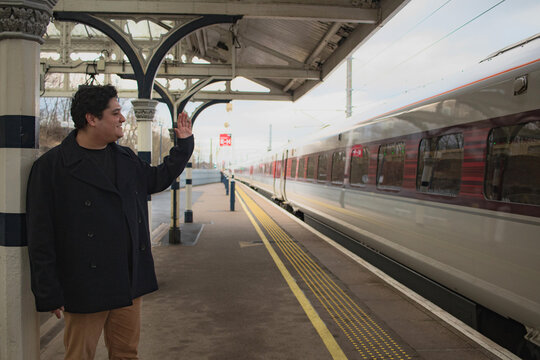 Man waving goodbye at train