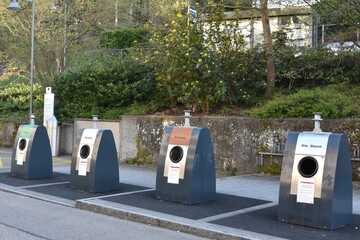 Waste management in town of Baden in Switzerland. Collection spot with garbage bins to collect...
