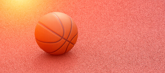 Orange basketball on brown court of gymnasium sport floor. Street basketball concept