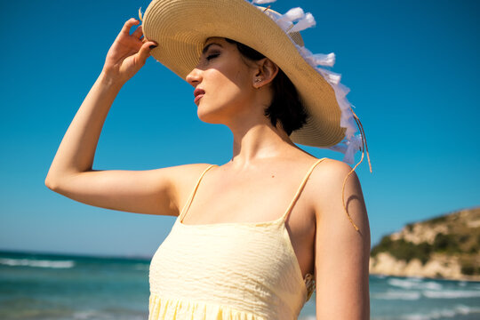 Portrait of a woman with a straw hat on the beach.