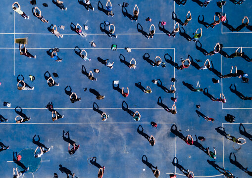 Aerial view from a drone of a group of people doing physical exercise on a jogging track