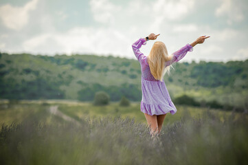 Fototapeta premium Beautiful fashion girl walking on a lavender