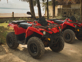 Fototapeta na wymiar Red ATV on the background of a tropical landscape