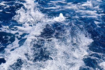 Abstract blue sea water with white wave for background. Adreatic sea, blue mediterranean sea. sea splash sailing boat trail on the water
