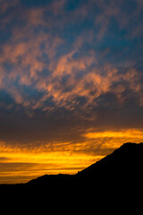 a flame yellow sunset with a mountain silhouette over the town of Marbella in Spain 
