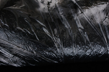 Anti-cellulite mud wrap procedure. Spa. Leather covered with black clay. Close-up. Skin care