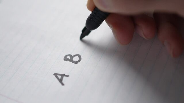 Writing The Alphabet Letter By Letter On a Paper With a Pen