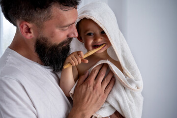 Father with toddler brushing teeth in bathroom