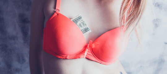 Breasts of woman and money in  bra as symbol of prostitution and illegal business.