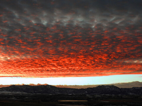 brilliant sunset  with mammatus clouds over the front range of the colorado rocky mountains, as seen form broomfield, colorado