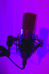 Close the studio condenser microphone with antivibration support real-time with blue and red backlight. Zoomed view, close-up.