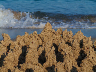 Built House sand castle with towers on the south shore of the sandy beach blue sea