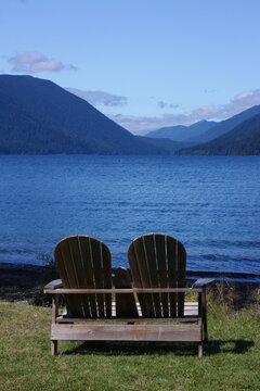 two adirondack chairs  on the shoreline of beautiful  lake crescent ion a sunny day, in olympic national park in western washington state