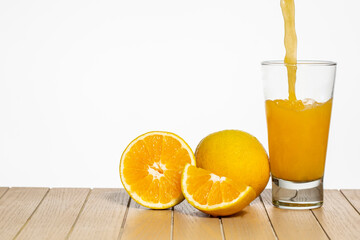 Glass with orange juice on table on white background