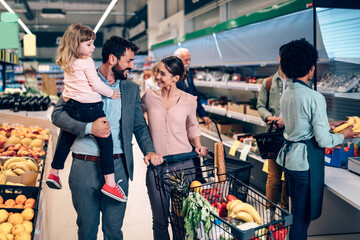 Happy young family buying groceries together at the supermarket.