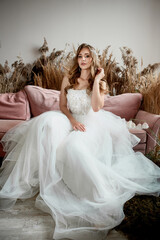 Fototapeta na wymiar Charming young bride in luxurious wedding dress. Pretty girl in white
