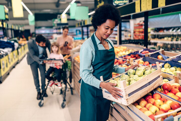 African American female employee working in grocery store.