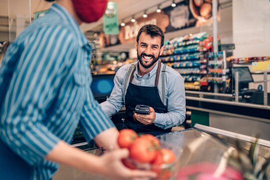 Woman buing fresh vegetables and fruits at grocery store.