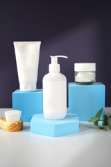 Cosmetic skincare container blank mockups in modern navy and blue styled setting with on trend shadow photography.