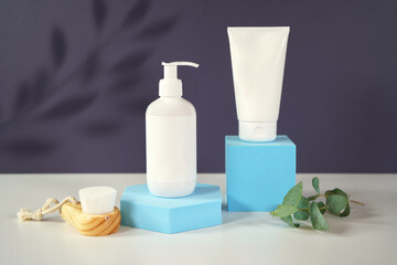 Cosmetic skincare container blank mockups in modern navy and blue styled setting with on trend shadow photography.