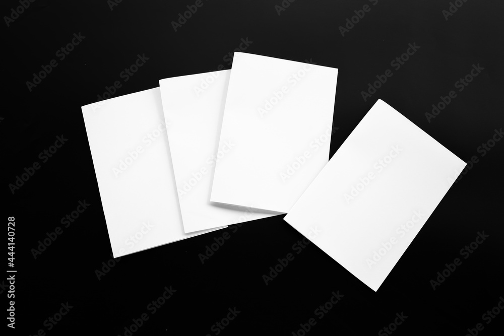 Wall mural Blank Mock-up paper. brochure magazine isolated on black table, changeable background , white paper isolated on dark tone.