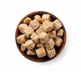 Brown sugar cubes on a wooden plate set against a white background.