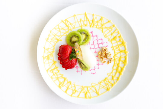 Strawberries & Kiwi Served With Dipping Sauce Served On White Plate. Overhead Shot