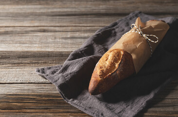 Cloth and baguette set against an old wooden background