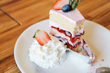 Eaten Strawberry and cream sponge cake. Homemade summer dessert on wooden rustic table