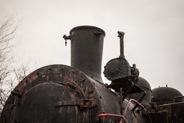 Close up on a steam locomotive chimney on an old machine that is now rusting and decaying, that was...
