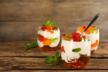 Delicious broken glass jelly dessert on wooden table, space for text