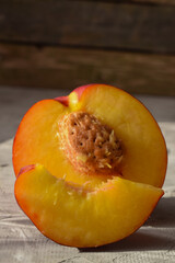 half of a nectarine with a bone and a slice in the foreground