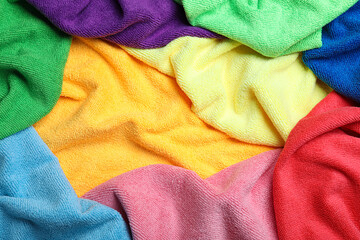 Many colorful microfiber cloths as background, closeup