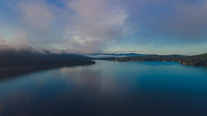 Minutes before sunrise with clouds and fog over the lake 