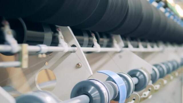 Close up of spinning spools during industrial sewing process