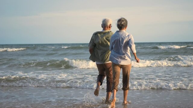 Happy Asian active senior man and woman couple lifestyle running to beach and enjoying funny, Romantic elderly enjoy travel summer vacation, plan life insurance at retirement couple concept - Powered by Adobe