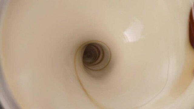 Close-up on Mesmerizing Soft Caramel Milkshake Drink Slowly Mixing, Top View