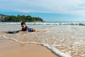 The waves swept the surf boy toward the shore..boy surfing on white waves..Paradise beach blue sea,...