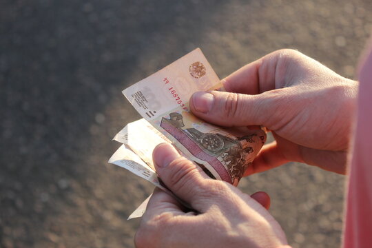 Female hands count Russian paper money in denomination of one hundred rubles, salary concept