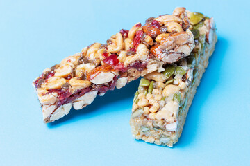 Two protein bars on blue background close-up, side view.