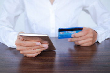 Staff woman holding credit mobile and credit card for pay via credit card. financial transactions shopping online. planing earn money investment and saving money for 2022 new year. business concept.