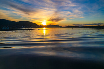 High cloud sunrise winter waterscape with ripples