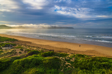 Early morning aerial views at the seaside with fog, cloud and waves