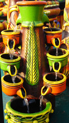 Collection of colorful pots and vases and also plates and bowls  in market for selling