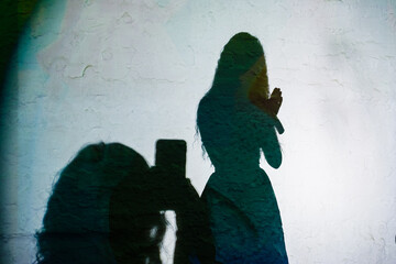 Black shade on the wall of model posing and the viewer taking pictures on the phone, home party show